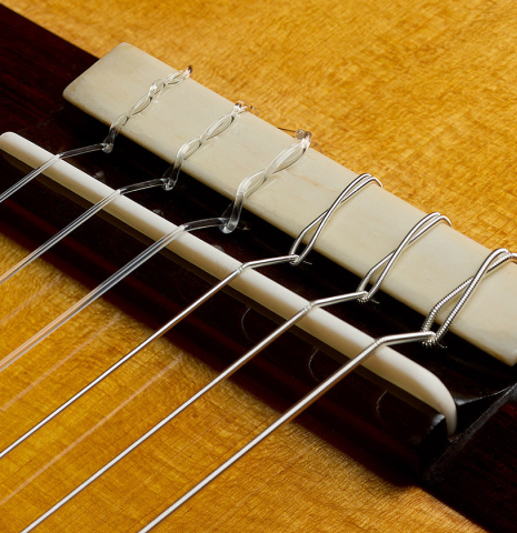 The bridge, tie-block and saddle of a 2025 Liuteria Frignani "1915 Enrique Garcia" classical guitar made of spruce and Indian rosewood