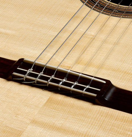 The soundboard, bridge, tie-block and saddle of a 2026 Hironori Fukuda classical guitar made of spruce and African rosewood