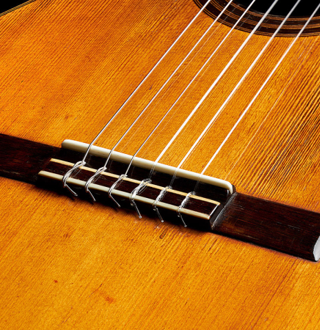 The bridge, tie-block and saddle of a 1903 Enrique Garcia classical guitar made of spruce and mahogany