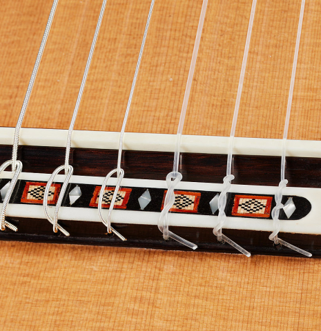 The bridge, tie-block and saddle of a 2024 Dario Garcia classical guitar made of cedar and African rosewood