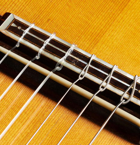 The bridge, tie-block and saddle of a 1918 Enrique Garcia classical guitar made of spruce and CSA rosewood
