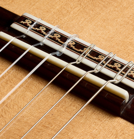The bridge, tie-block and saddle of a 2025 Darío García classical guitar made of sitka spruce and Indian rosewood
