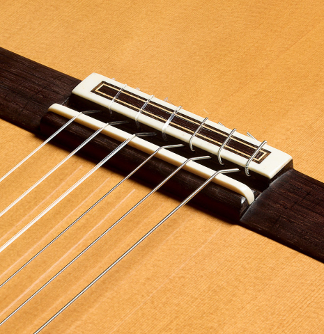 The bridge, tie-block and saddle of a 2024 Francisco Navarro Garcia "Rodriguez" classical guitar made of cedar and Indian rosewood