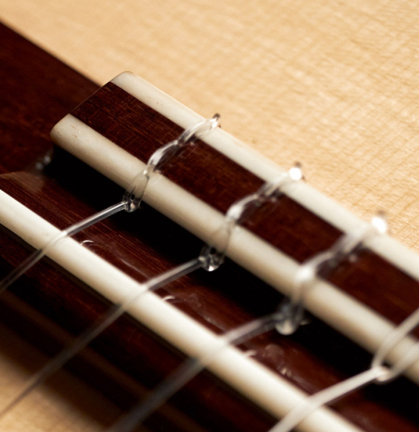 The bridge, tie block and saddle of a 2023 Pavel Gavryushov classical guitar made of spruce and African rosewood