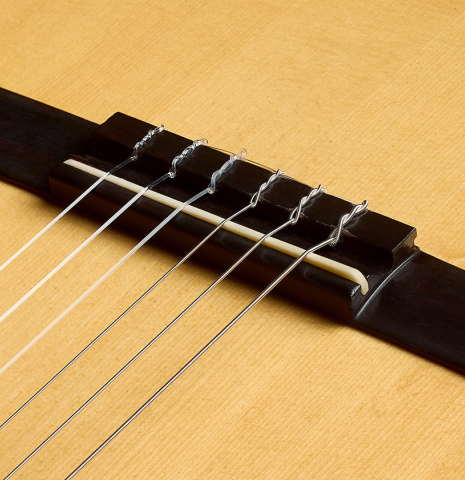 The bridge, tie-block and saddle of a 1972 Giannini AW-80 classical guitar made of spruce and CSA rosewood
