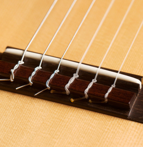This is a close-up of the bridge, tie-block and saddle of a 1994 Gioachino Giussani SP/MP classical guitar, ex Angel Romero