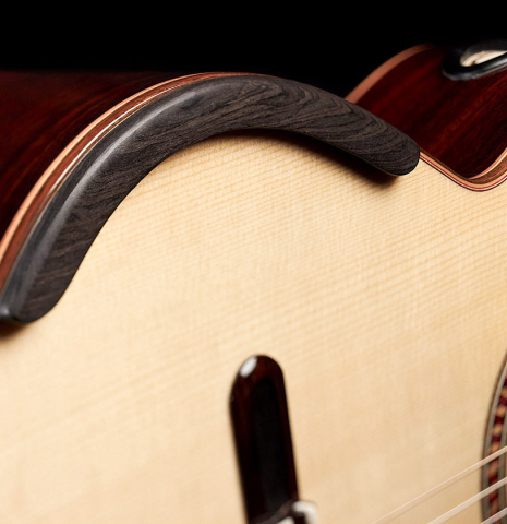 The arm support of a 2021 Yulong Guo &quot;Chamber Concert&quot; classical guitar made with spruce top and Indian rosewood back and sides.