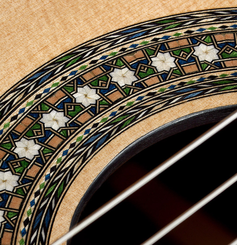 Closeup of the rosette of a 2024 Miguel Angel Gutierrez classical guitar made of spruce and Indian rosewood.