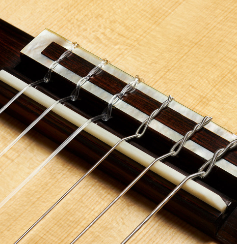 The bridge, tie-block and saddle of 2024 Henner Hagenlocher "640" classical guitar made of spruce and CSA rosewood