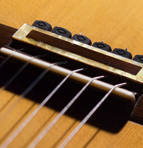 The bridge of a 2008 Henner Hagenlocher classical guitar made of cedar and CSA rosewood
