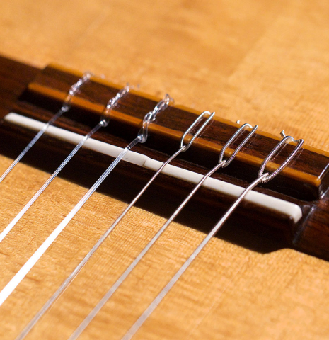 The bridge of a 1992 Hermann Hauser III classical guitar made with spruce top and CSA rosewood back and sides.