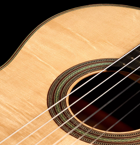 The bearclaw spruce soundboard and rosette of a 2022 Kathrin Hauser "Segovia" classical guitar made of spruce and Indian rosewood.
