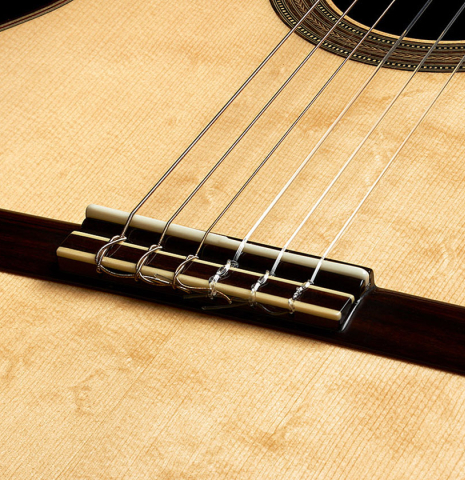 The bridge, tie-block and saddle of a 2019 Kathrin Hauser "Segovia" classical guitar made of spruce and Indian rosewood.