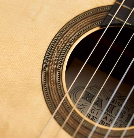 The bearclaw spruce soundboard and rosette of a 2019 Kathrin Hauser "Segovia" classical guitar made of spruce and Indian rosewood.