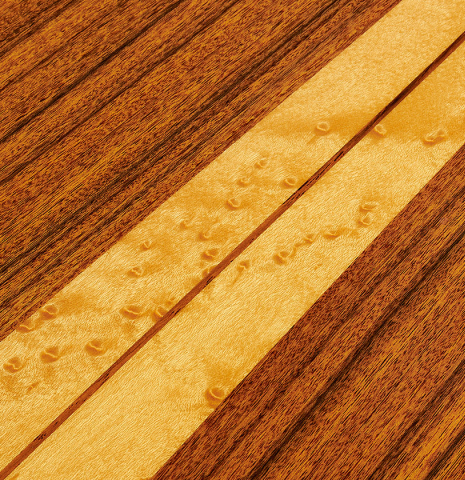 The back center seam with central maple wedge of a 2002 Hermann Hauser III classical guitar made of spruce and pau ferro
