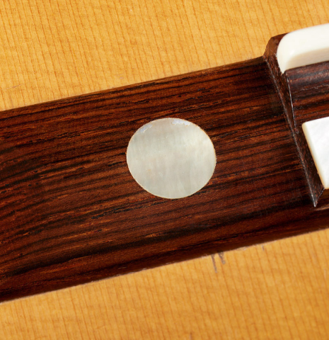 The wing of the bridge with MOP inlay of a 1934 Hermann Hauser I classical guitar made of spruce and CSA rosewood