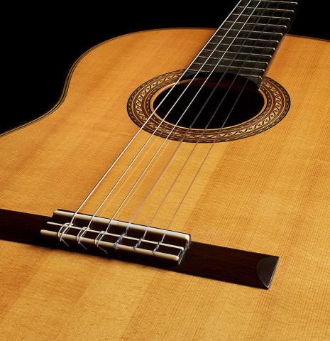 The soundboard and bridge of a 2000 Hermann Hauser III classical guitar made of spruce and CSA rosewood