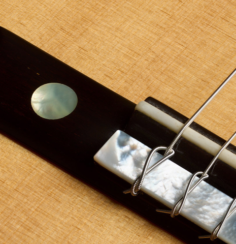 The bridge, tie-block and saddle of a 2016 Hermann Hauser III classical guitar (ex Marcelo Kayath) made of spruce and maple