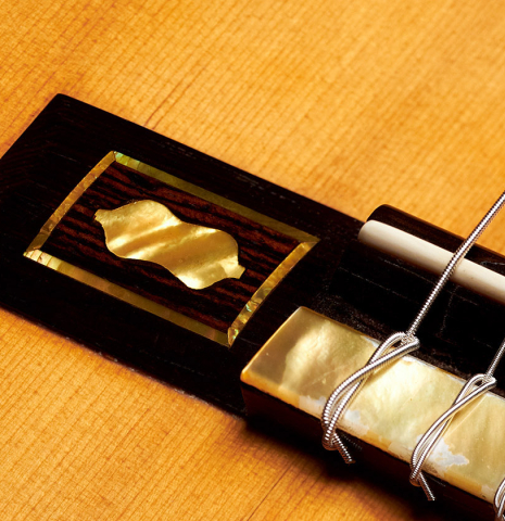 The bridge and tie block of a 1930 Santos Hernandez Spanish vintage classical guitar made with spruce top and CSA rosewood. 