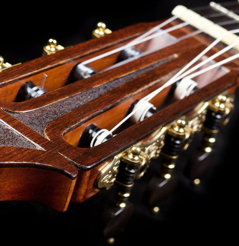 The carved headstock veneer of a 1966 Hernandez y Aguado classical guitar made of spruce and CSA rosewood