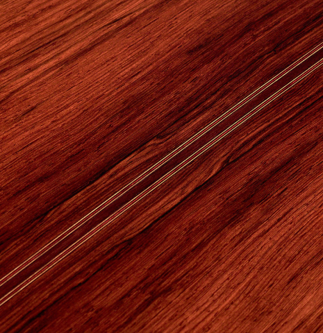 The back wood of a 2022 Dietmar Heubner classical guitar made with spruce and African rosewood