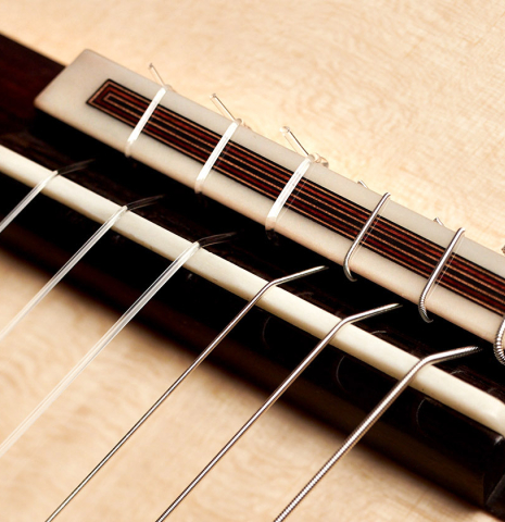 The bridge and saddle of a 2023 Dietmar Heubner classical guitar made with spruce and African rosewood
