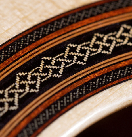 Closeup of the rosette of a 2021 Dietmar Heubner classical guitar made of spruce and cocobolo.