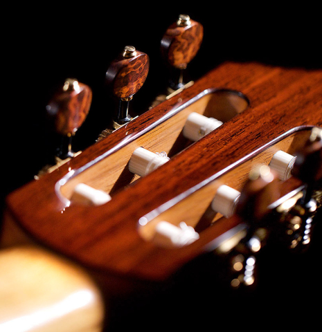 The back headstock veneer and tuning machines of a 2021 Dietmar Heubner classical guitar made of spruce and cocobolo.