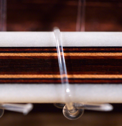 Closeup of the tie block of a 2021 Dietmar Heubner classical guitar made of spruce and cocobolo.