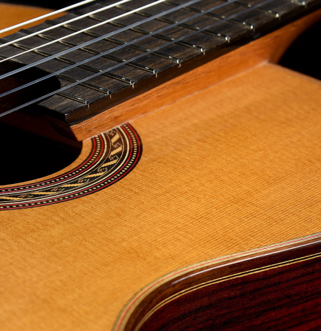 The top and raised fingerboard of a 2025 Kenny Hill "Signature CD/SP" classical guitar made of a cedar/spruce double top and Indian rosewood
