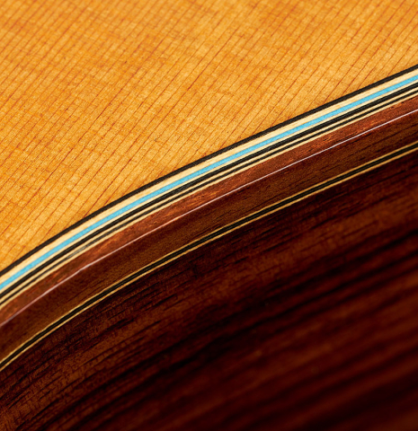 The purflings at the soundboard and sides of a 2020 Kenny Hill "Heritage" classical guitar made of cedar and Indian rosewood
