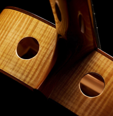 The dual soundports on the sides of a 2015 Kenny Hill "Performance 640 SP/CD" classical guitar made of spruce and maple