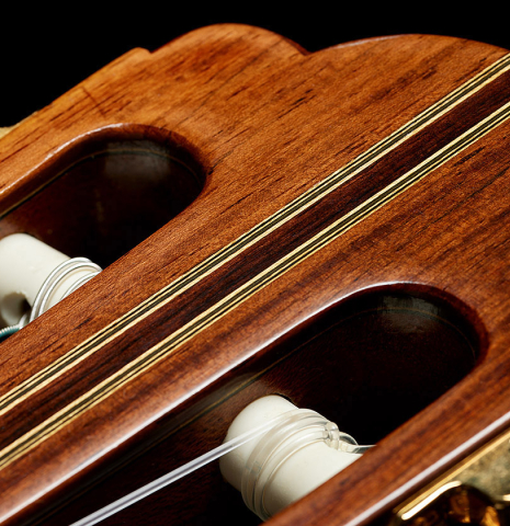 The headstock veneer and tuning machines of a 2008 Kenny Hill "1937 Hauser" classical guitar made of spruce and Indian rosewood