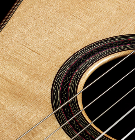 The soundboard and rosette detail of a 2008 Kenny Hill "1937 Hauser" classical guitar made of spruce and Indian rosewood