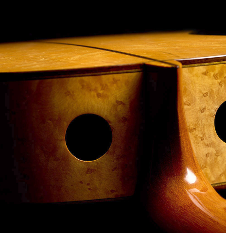 The side soundports of a 2009 Kenny Hill "Torres 640 Lattice Double Top" classical guitar made of spruce and maple