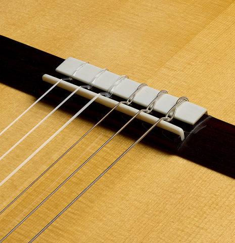 The bridge, tie-block and saddle of a 2025 Kenny Hill "Torres 640" classical guitar made of spruce and CSA rosewood