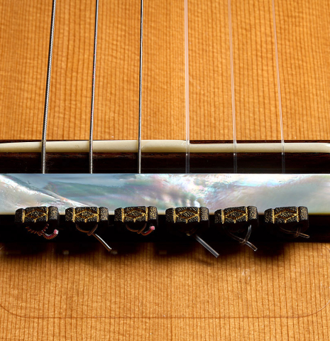 The bridge, tie-block and saddle of a 2020 Kenny Hill "Special CD/SP" made of cedar/spruce and Indian rosewood