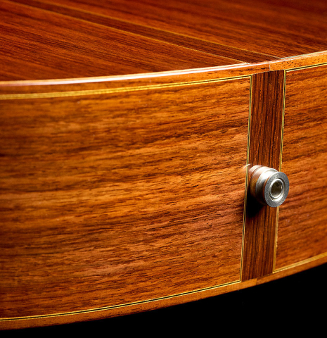 The sides at the foot with 1/4 inch endpin of a 2010 Kenny Hill "Signature CD/SP" classical guitar with electronics made of cedar/spruce and Indian rosewood