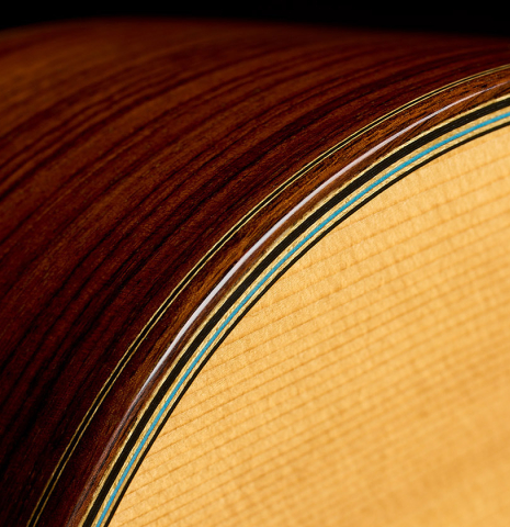The top binding and purfling of a 2020 Kenny Hill "Heritage" classical guitar made of spruce and Indian rosewood
