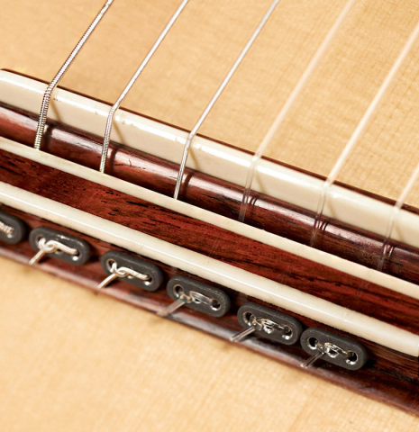 The bridge and saddle of a 2006 Thomas Humphrey "Millennium" classical guitar made with spruce and CSA rosewood.