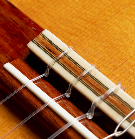 The bridge, tie-block and saddle of a 1993 Thomas Humphrey "Millennium" classical guitar made with spruce and CSA rosewood.
