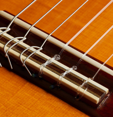 The bridge, tie-block and saddle of a 1988 Thomas Humphrey "pre-Millenium" classical guitar made of spruce and CSA rosewood