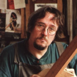 Thomas Humphrey holding a guitar neck in his New York workshop