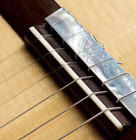 The bridge, tie-block and saddle of a 2026 Brian Itzkin "635" classical guitar made of spruce and CSA rosewood