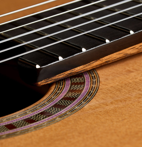 The elevated fingerboard of a 2025 Wolfgang Jellinghaus "Signature CD/CD" classical guitar made of cedar and granadillo
