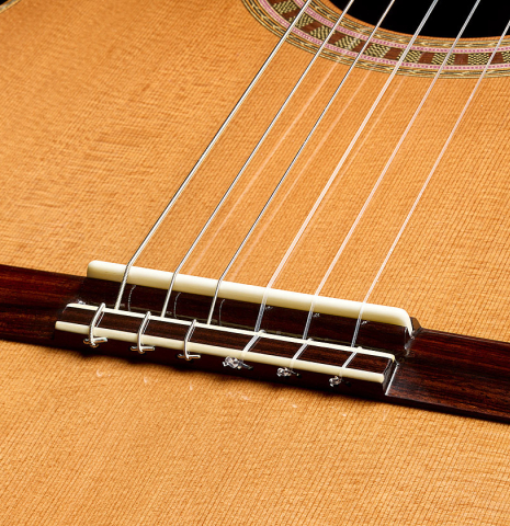 The bridge, tie-block and saddle of a 2025 Wolfgang Jellinghaus "Signature CD/CD" classical guitar made of cedar and ziricote