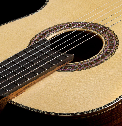 The elevated fingerboard and soundboard of a 2026 Wolfgang Jellinghaus "Signature SP/SP" classical guitar made of spruce/spruce top and granadillo back and sides