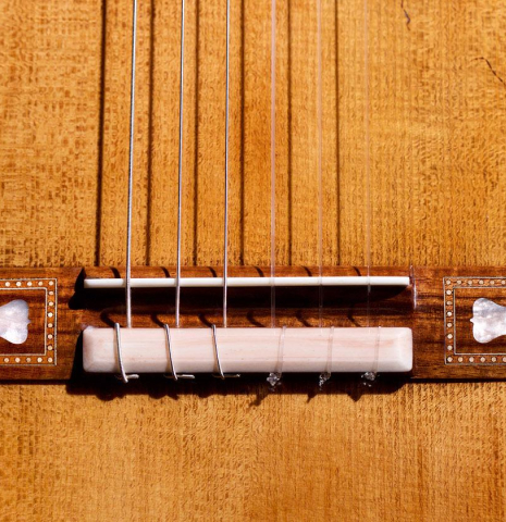 The bridge of a 2023 Wolfgang Jellinghaus “Torres 43” classical guitar made with spruce and maple.