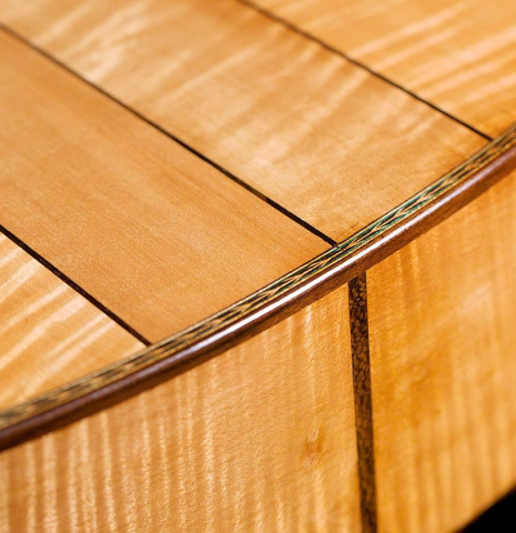 The lower bout of a 2023 Wolfgang Jellinghaus “Torres 43” classical guitar made with spruce and maple.
