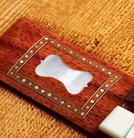 The mother-of-pearl inlay in the bridge of a Wolfgang Jellinghaus “Torres 43” classical guitar made with spruce and maple.